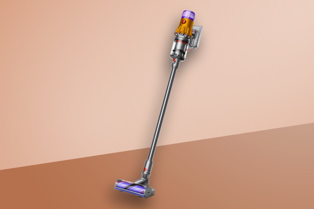 Dyson V12 Detect Slim Absolute vacuuming up on a brown background