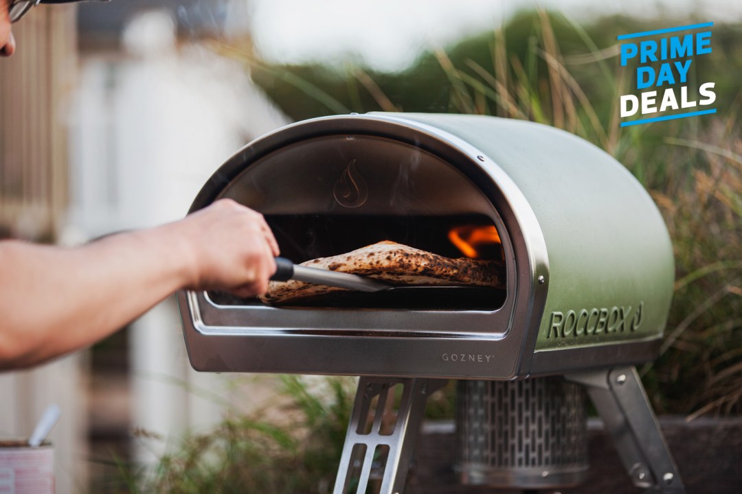 Man taking pizza out of Gozney Roccbox pizza oven