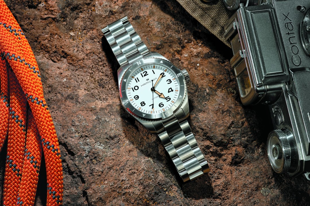 Hamilton Khaki Field on a rock, surrounded by outdoors gear