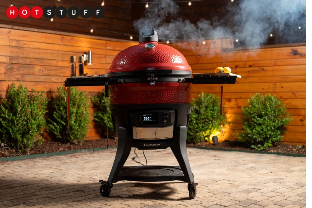 A Kamado Joe Big Joe Konnected Joe barbecue in a garden with smoke